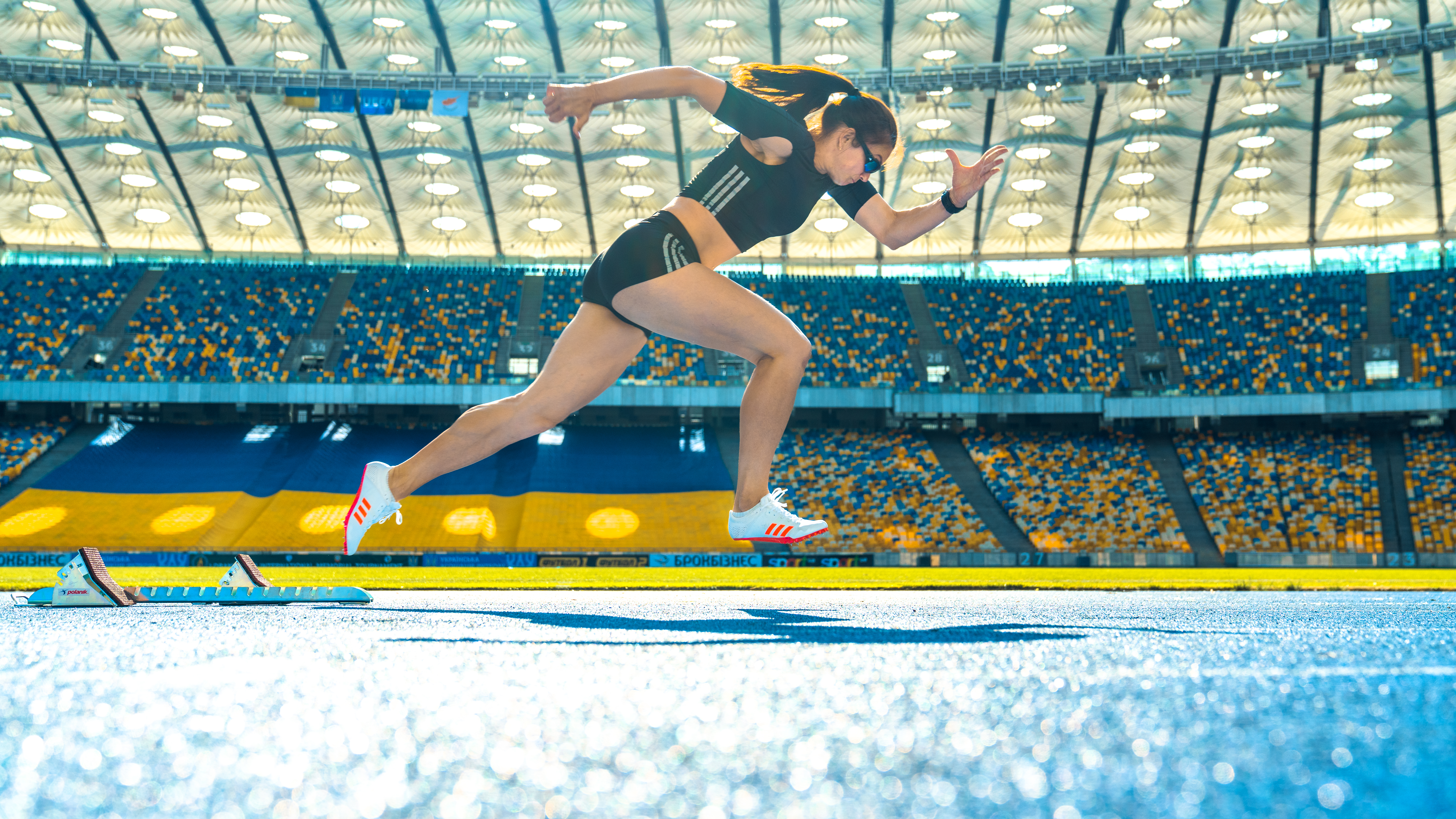 Woman sprinting on a track in a stadium