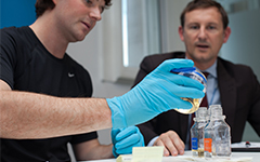 Person showing another person how to do a urine sample test